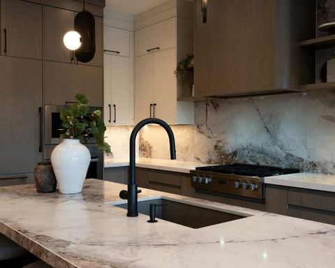 Quartzite island and full-height backsplash in a white oak kitchen