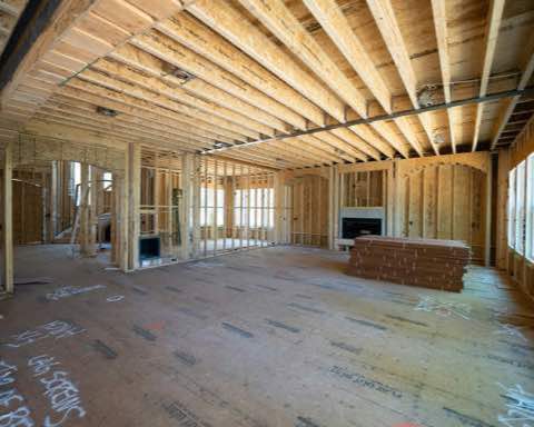 Interior framing of a home under construction with studs and floor joists exposed